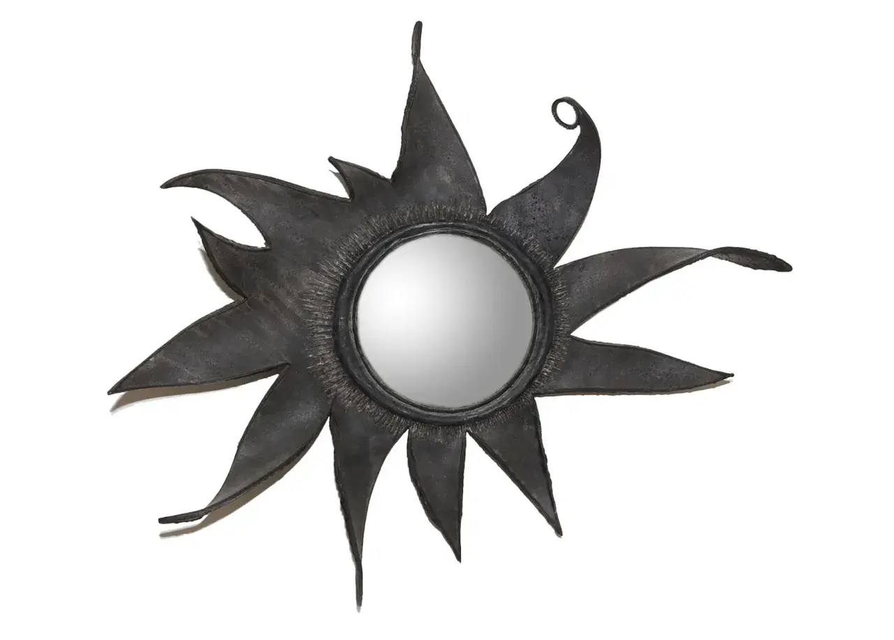Miroir soleil en métal noir, aux rayons stylisés et pointus, rappelant l'éclat d'une étoile. Un design audacieux, digne d'une ligne Vautrin.