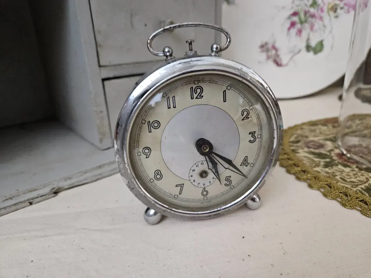 Un réveil ancien, objet de collection, prêt pour une estimation. Son cadran patiné et ses aiguilles racontent une histoire.