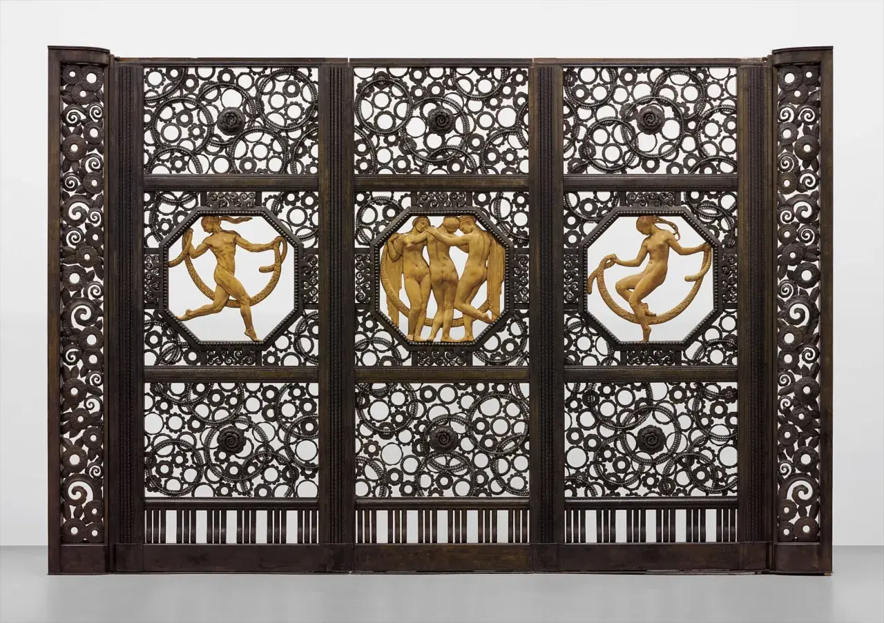 Porte monumentale en fer forgé, signature Edgar Brandt. Trois panneaux ornés de figures nues et de motifs circulaires complexes.