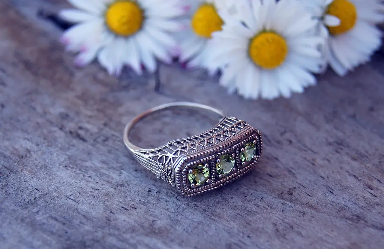 Bague ancienne en argent avec trois pierres vertes, ornée de dentelle filigrane. Une pièce parfaite pour une estimation bague ancienne.