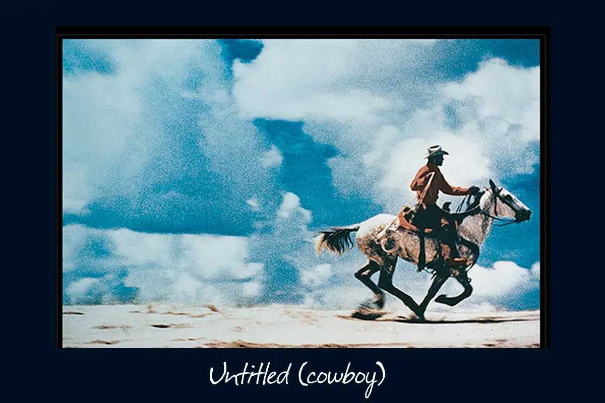 Un cowboy au chapeau monte un cheval blanc au galop sous un ciel bleu et nuageux, une œuvre emblématique de Richard Prince.