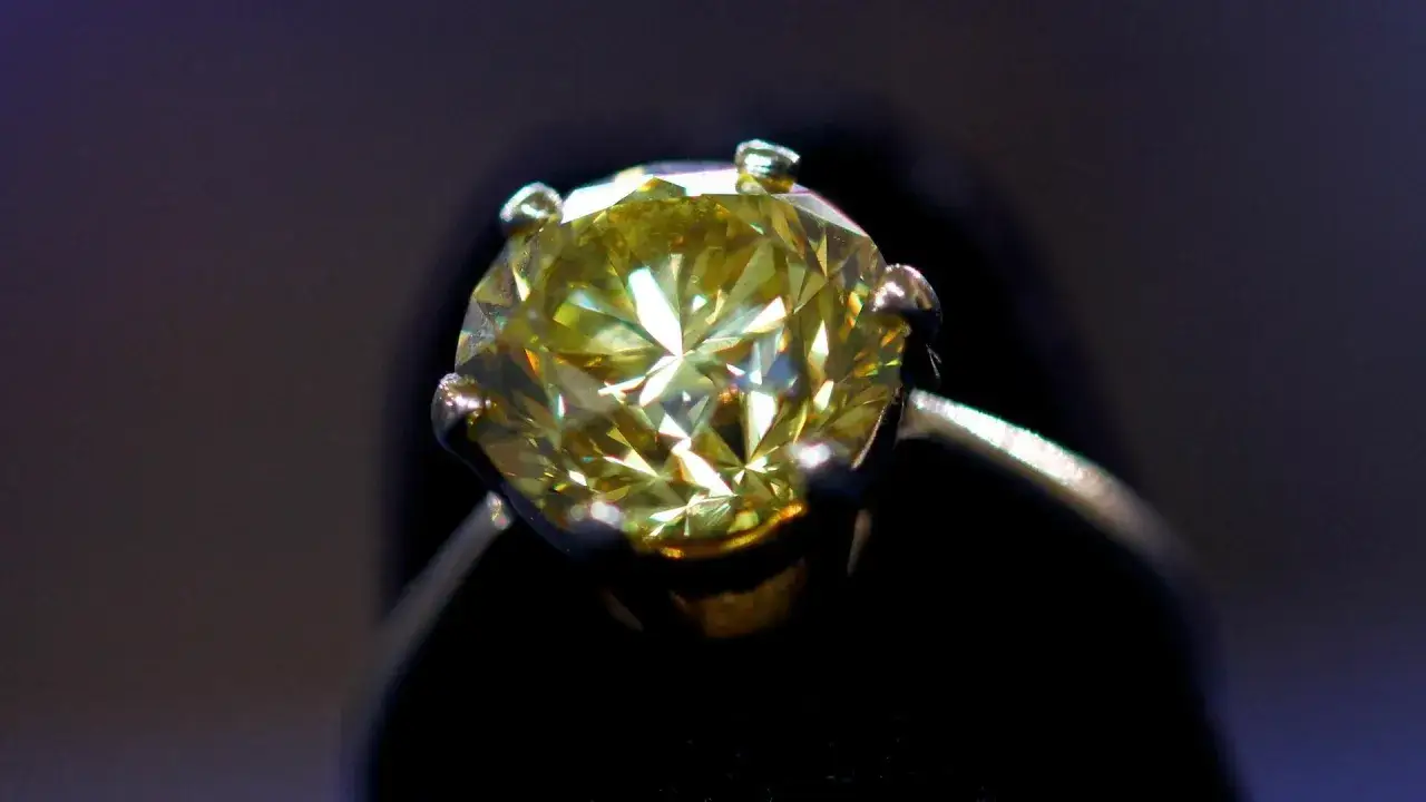 Gros plan d'une bague ancienne sertie d'un diamant jaune &eacute;tincelant, parfait pour une estimation.
