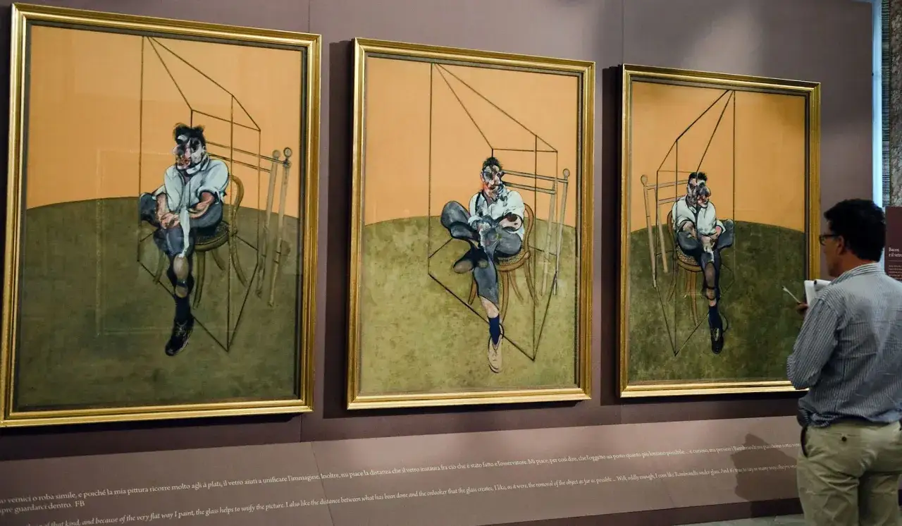 Trois œuvres d'art de Francis Bacon, représentant des figures assises dans des cages stylisées, exposées dans un musée.