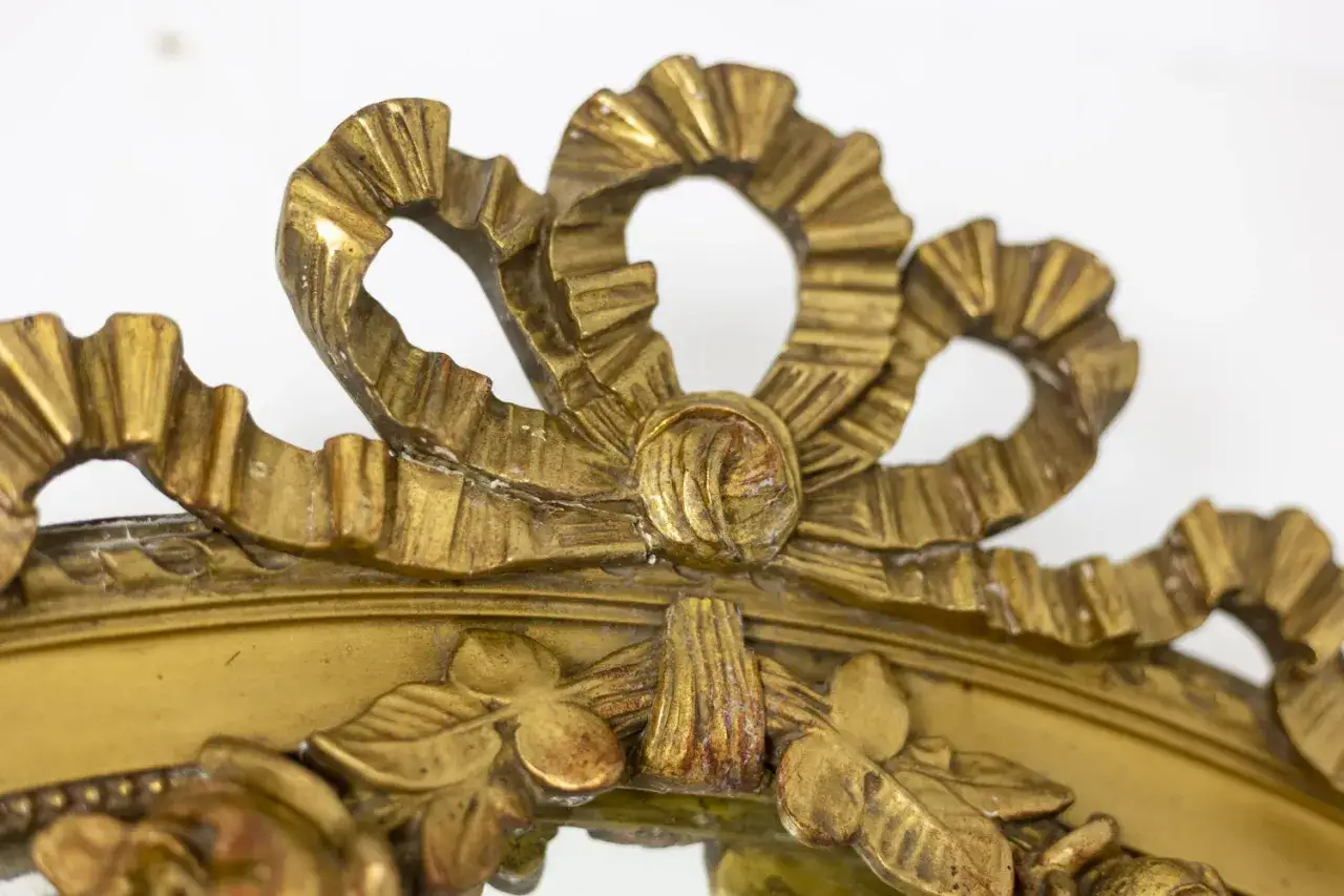 D&eacute;tail d'un cadre dor&eacute; orn&eacute; de rubans sculpt&eacute;s, &eacute;voquant le style de Hubert Le Gall.