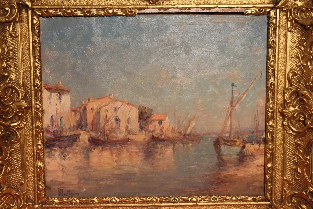 Un port m&eacute;diterran&eacute;en baign&eacute; de lumi&egrave;re, peint par Malfroy, peintre de talent. Des maisons blanches et des voiliers se refl&egrave;tent dans l'eau calme.